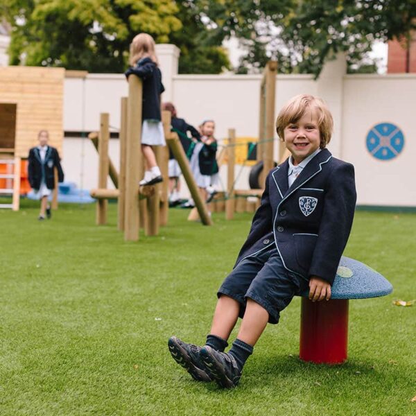 Boy Sitting On Mushroom Seat In Play Ground