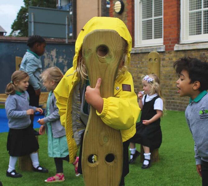 Child looking through the eyeholes on the forest seats