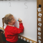 Child writing on the Magnetic Dry Wipe