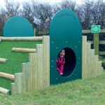 Girl Playing On Dino Mound and Tunnel