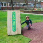 Child Kneeling infront of the bug hotel