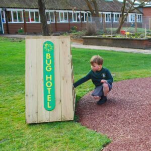 Child Kneeling infront of the bug hotel