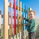 Child hitting the post mounted chimes