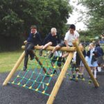 Children on cargo net climber in school playground