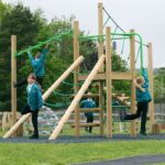Children playing on treetops three playground equipment