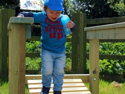 Child runs across a wood bridge