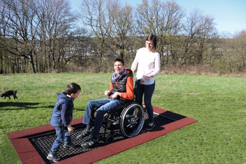 Trampoline in a park with a man in a wheelchair on the trampoline