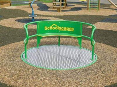 Green Schoolscapes SEN inclusive roundabout on rubber safety surfacing in a school playground
