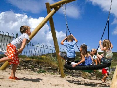 Children playing on a flat nest eagle swing at a playground installed by Schoolscapes UK