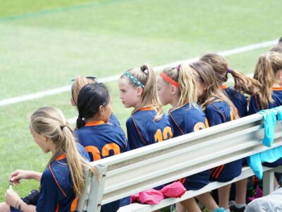 school girls sports team sat on bench
