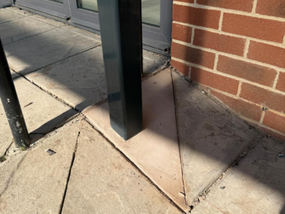 Base of a steel canopy post set into concrete paving outside